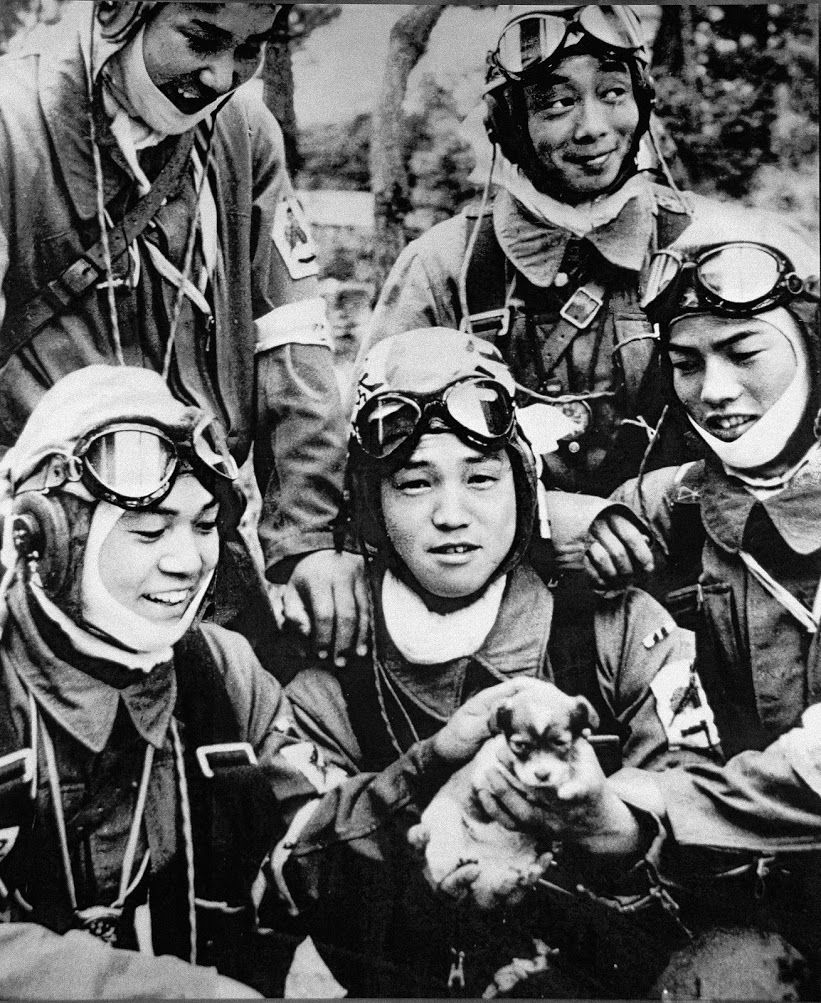 أفراد القوات الخاصة يحتضنون كلبًا صغيرًا (26 مايو/ أيار عام 1945). التقطت الصورة في مطار بانسي في كاغوشيما قبل ساعتين من ساعة الهجوم.