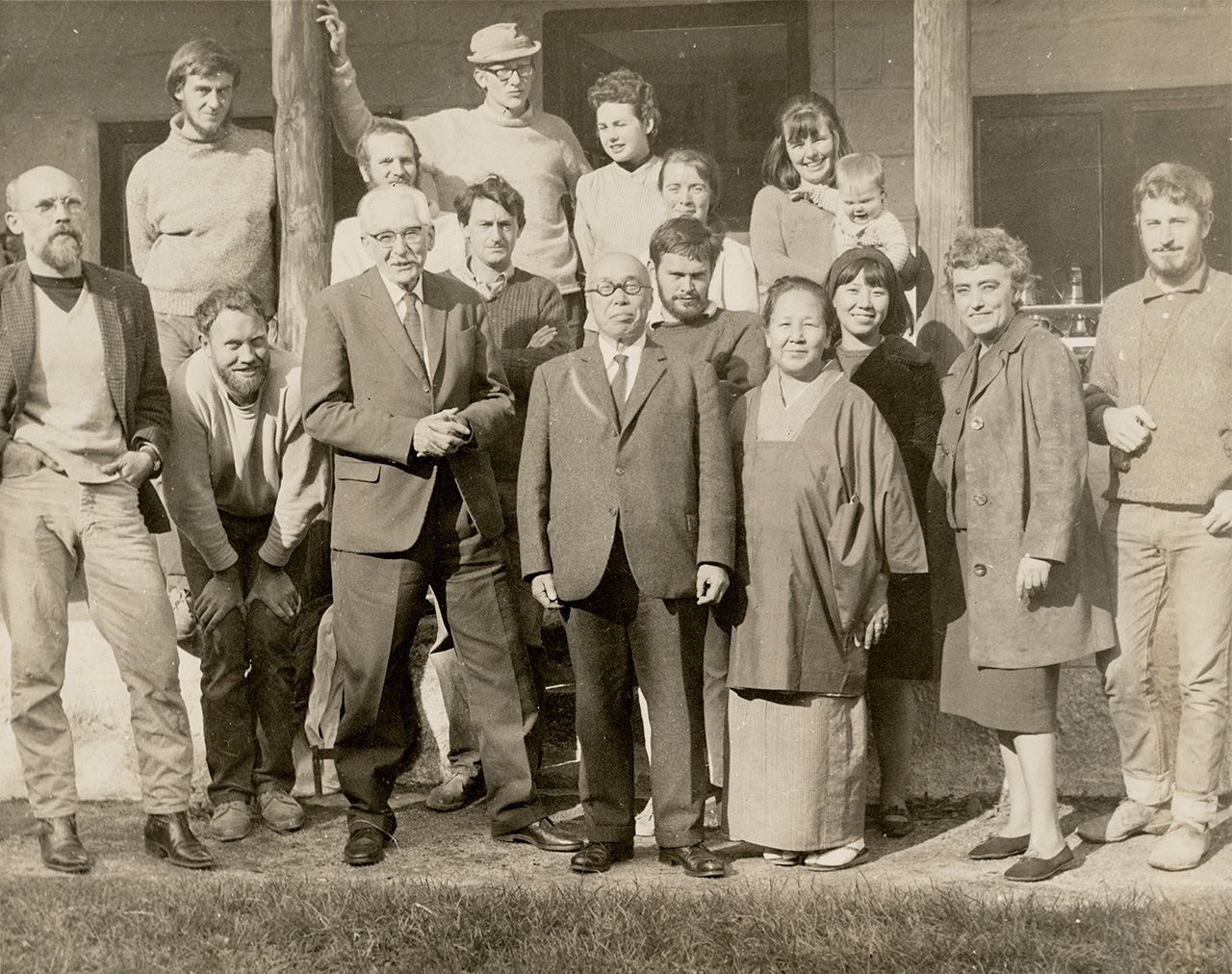 برنارد ليتش (الثالث من اليسار، في الأمام) وهامادا شوجي (في الوسط، بجانبه) في ورشة ليتش لصناعة الخزف مع موظفي المنشأة، 1960 (إهداء من مركز دراسة المصنوعات اليدوية)