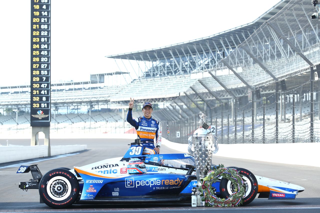 ساتو يقف مع سيارته بجوار كأس بورغ وورنر الذي تم تقديمه للفائز بسباق إينديانابوليس 500. ويحمل الكأس صورة واسم الفائزين في السباقات 104 التي أقيمت حتى الآن، وأصبح ساتو واحدًا من 20 متسابقًا فقط استطاعوا المشاركة لأكثر من مرة.