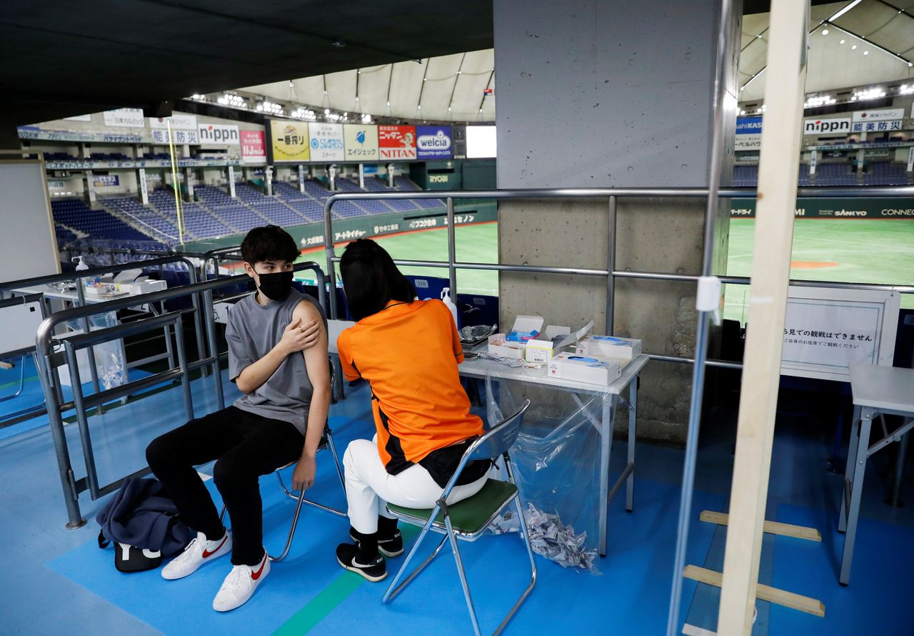  رجل يتلقى جرعة من لقاح فيروس كورونا في طوكيو دوم، موطن فريق البيسبول الياباني المحترف يوميوري جاينتس والذي يستخدم كمركز للتطعيم ضد مرض فيروس كورونا في طوكيو، اليابان في 16 أغسطس/ آب 2021. رويترز / إيسى كاتو.