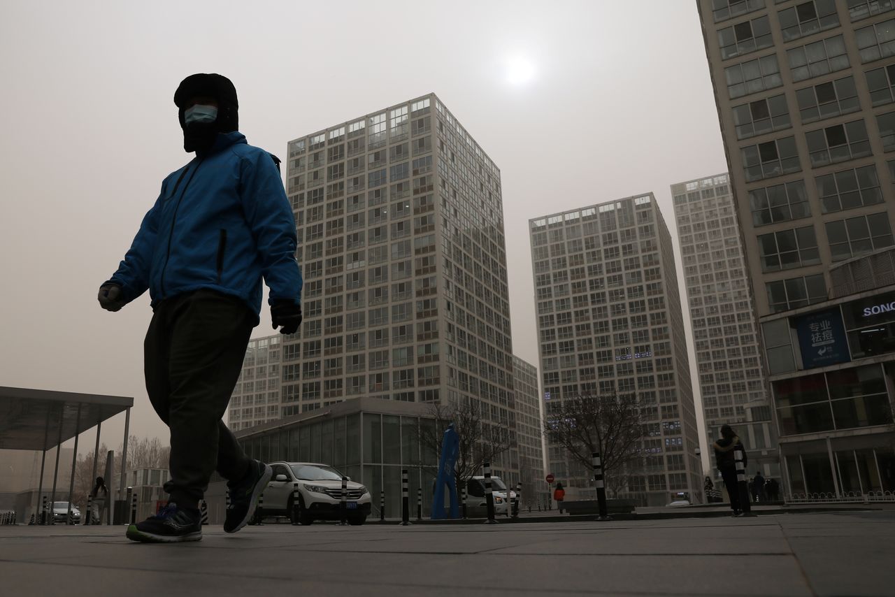 رجل يضع كمامة يسير في بكين يوم 15 مارس آذار 2021. تصوير: تينجشو وانغ - رويترز