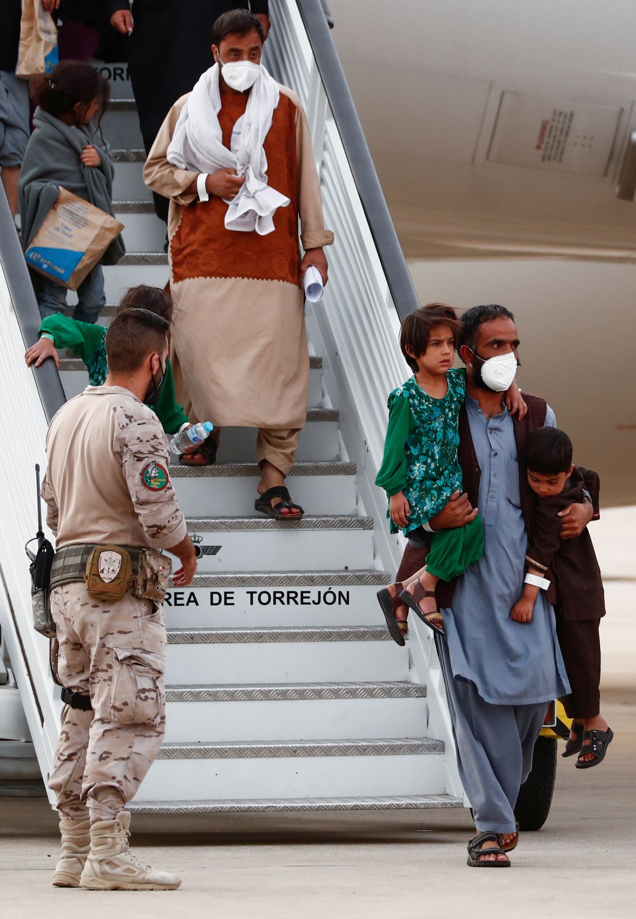 مدنيون أفغان تم إجلاؤهم من كابول يصلون إلى قاعدة توريخون الجوية في توريخون دي أردوز  على مشارف العاصمة الاسبانية مدريد يوم الثلاثاء. تصوير:رويترز.