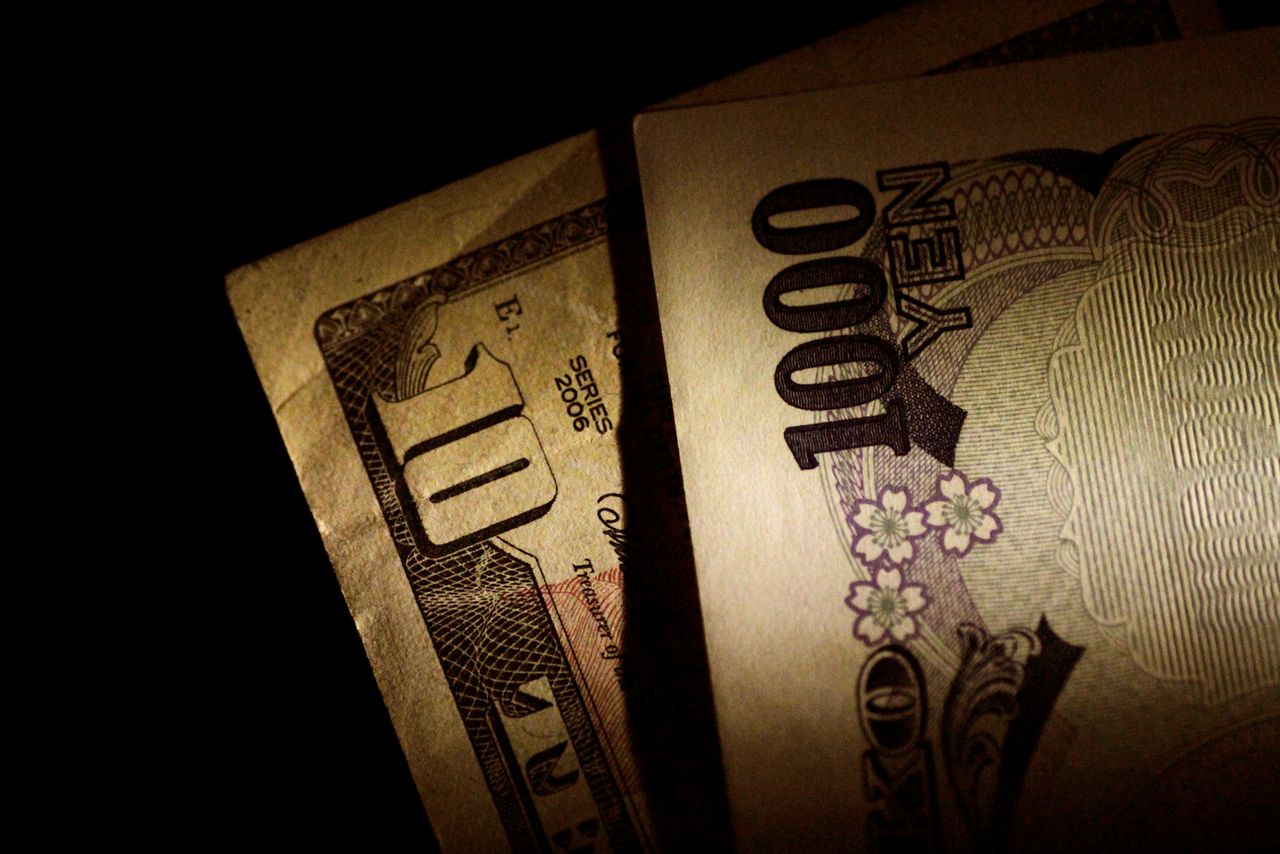 ورقة مالية من الين الياباني وأخرى من الدولار الأمريكي بصورة من أرشيف رويترز.