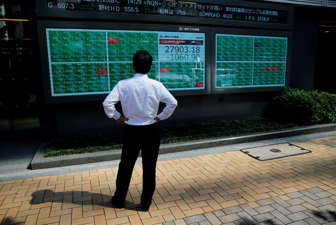 رجل يتابع حركة الأسهم عبر لوحة إلكترونية خارج بورصة طوكيو في 21 يونيو حزيران 2021. رويترز