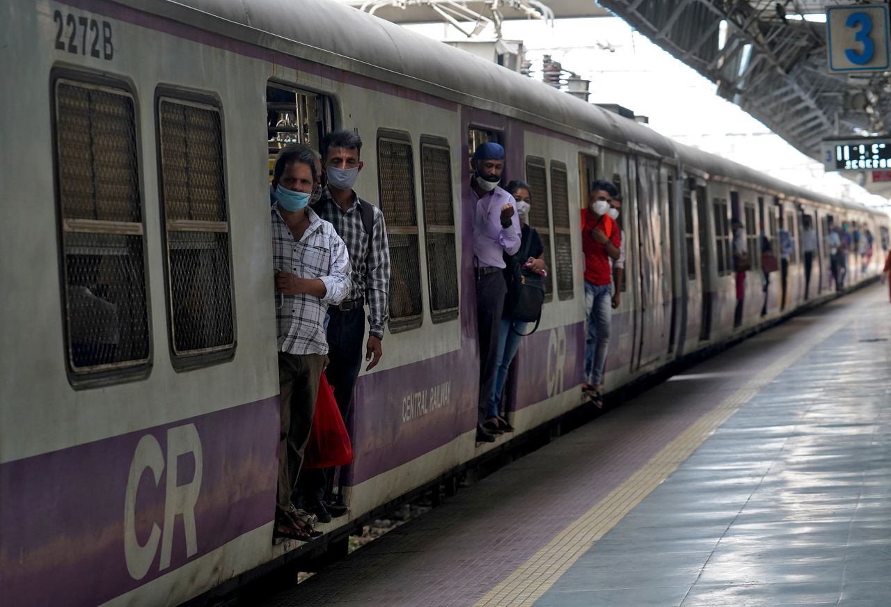 أشخاص يضعون كمامات يركبون قطارا في مومباي في صورة من أرشيف رويترز.