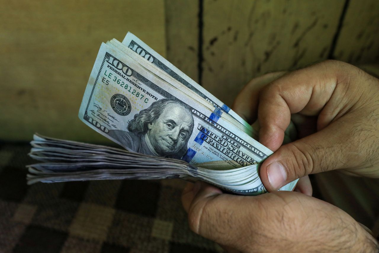 أوراق مالية فئة 100 دولار في مكتب صرافة بباكستان. رويترز