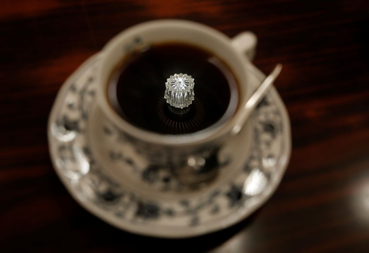   انعكاس لمصباح على شكل جوهرة على السقف في فنجان قهوة في مقهى هيكلن لصاحبه شيزو موري بطوكيو، اليابان، 8 أكتوبر/ تشرين الأول 2021. رويترز / كيم كيونغ هون.