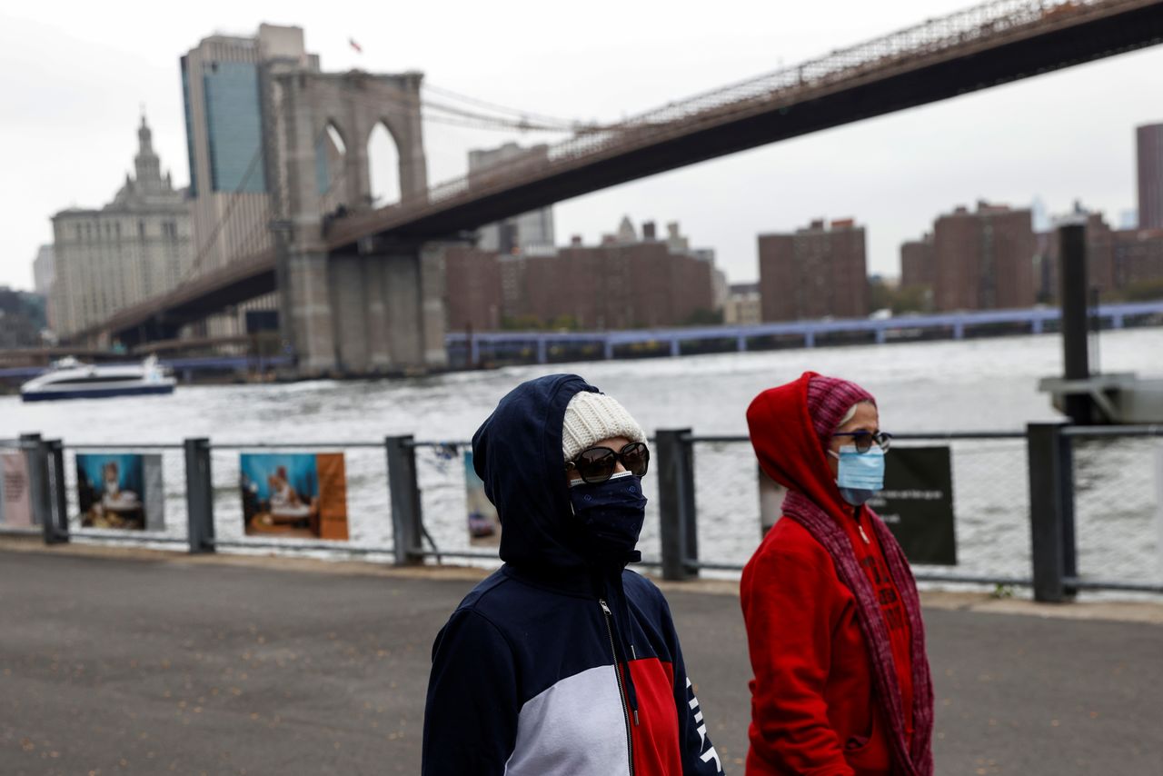 امرأتان تضعان كمامتين تسيران بالقرب من جسر بروكلين في مدينة نيويورك يوم 13 أكتوبر تشرين الأول 2021. تصوير: شانون ستابلتون - رويترز