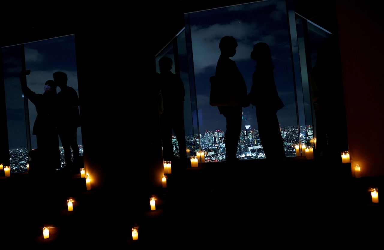  زائرون يلتقطون صورًا لمنظر طوكيو الليلي خلال مناسبة ”توتالي دارك تايم“، حيث يتم إطفاء جميع الأضواء الكهربائية واستخدام أضواء الشموع بدلاً من ذلك، في مرصد مبنى صن شاين بعد تخفيف الضوابط الاحترازية لفيروس كورونا في طوكيو باليابان في الخامس عشر من أكتوبر/ تشرين الأول 2021. رويترز/كيم كيونغ هون.