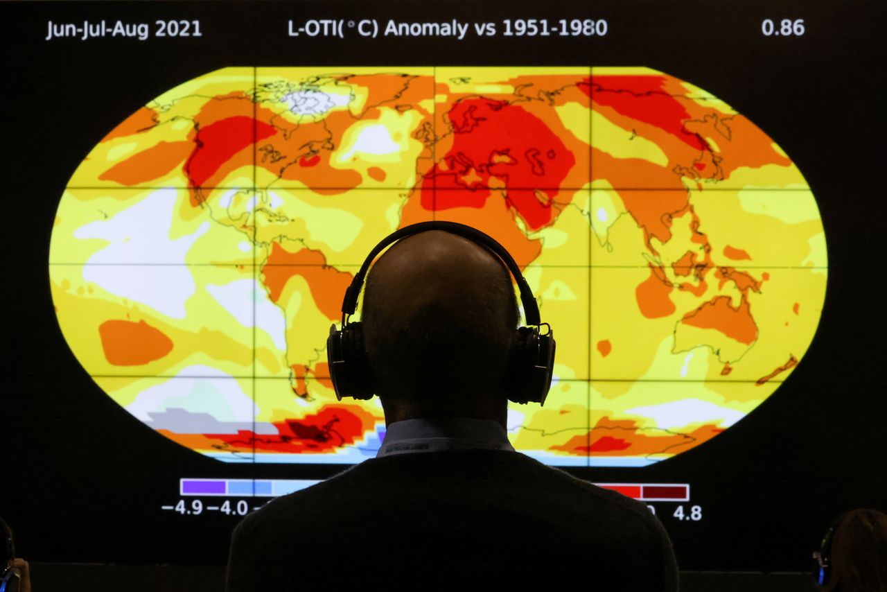 أحد المشاركين في قمة الأمم المتحدة للمناخ المنعقدة في جلاسجو باسكتلندا ينظر إلى شاشة تعرض لكوكب الأرض يوم الاثنين. تصوير:رويترز.