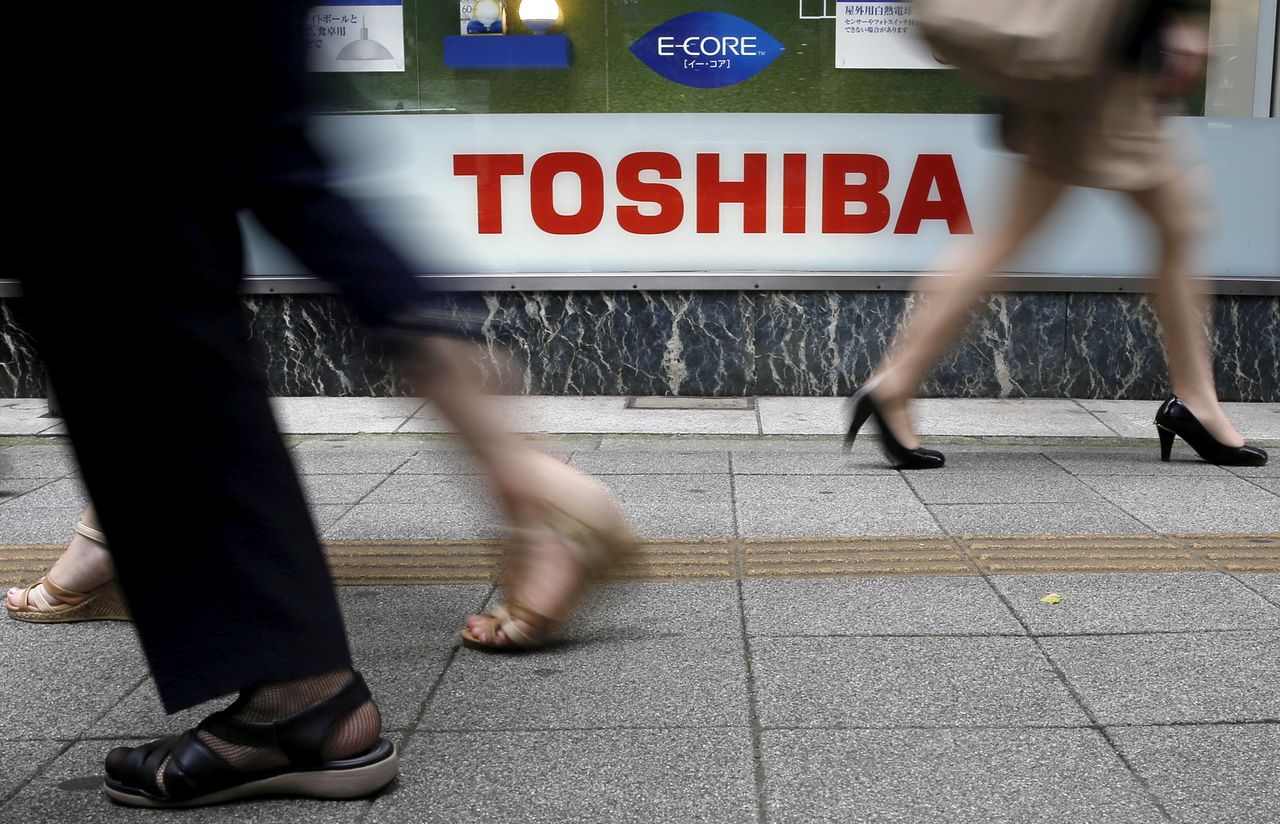  مشاة يمرون بجوار شعار شركة توشيبا خارج متجر لبيع الأجهزة الإلكترونية بالتجزئة في طوكيو، 14 سبتمبر/ أيلول 2015. تورو هاناي/ توشيبا 