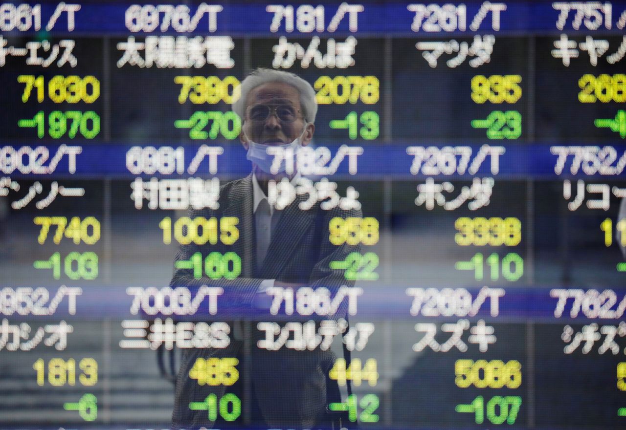 صورة أحد المارة تنعكس على سطح لوحة إلكترونية تعرض حركة المؤشرات خارج بورصة طوكيو في 21 سبتمبر أيلول 2021. رويترز