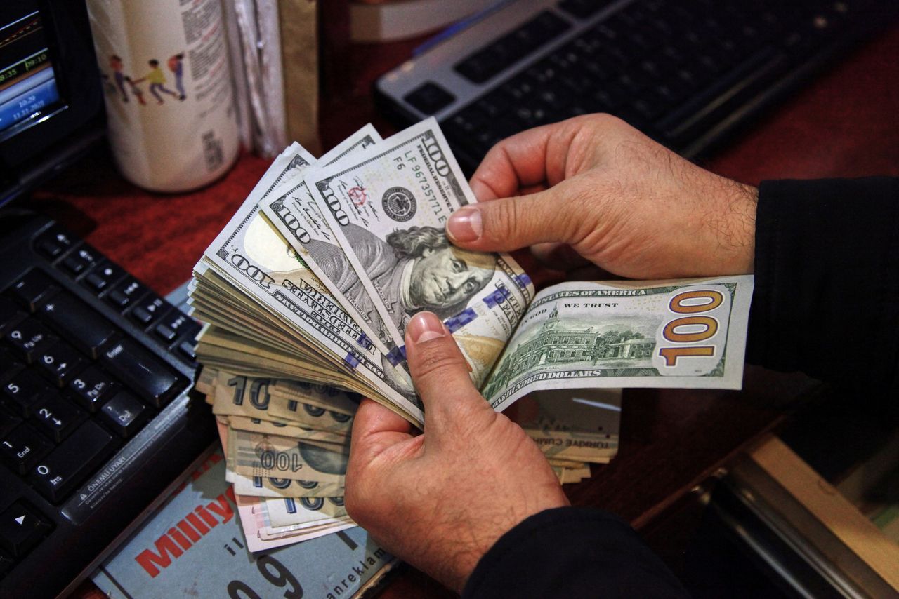 موظف في مكتب صرافة في العاصمة التركية أنقرة يعد أوراق بنكنوت من فئة 100 دولار أمريكي يوم 11 نوفمبر تشرين الثاني 2021. تصوير: جالا جيردوان - رويترز.