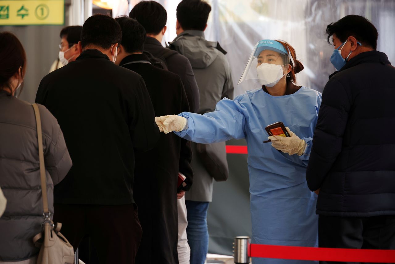 عاملة في المجال الصحي توجه أشخاصا ينتظرون الخضوع لاختبارات للكشف عن فيروس كورونا في موقع اختبار بسول يوم 10 نوفمبر تشرين الثاني 2021. تصوير:رويترز.