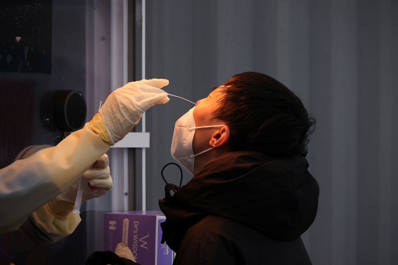 موظف طبي يحصل على مسحة من رجل لإجراء اختبار للإصابة بفيروس كورونا في مكان للاختبارات في سول عاصمة كوريا الجنوبية يوم 10 نوفمبر تشرين الثاني 2021. تصوير: كيم هونج-جي - رويترز.