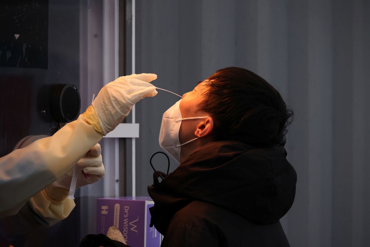 موظف طبي يحصل على مسحة من رجل لإجراء اختبار للإصابة بفيروس كورونا في مكان للاختبارات في سول عاصمة كوريا الجنوبية يوم 10 نوفمبر تشرين الثاني 2021. تصوير: كيم هونج-جي - رويترز.