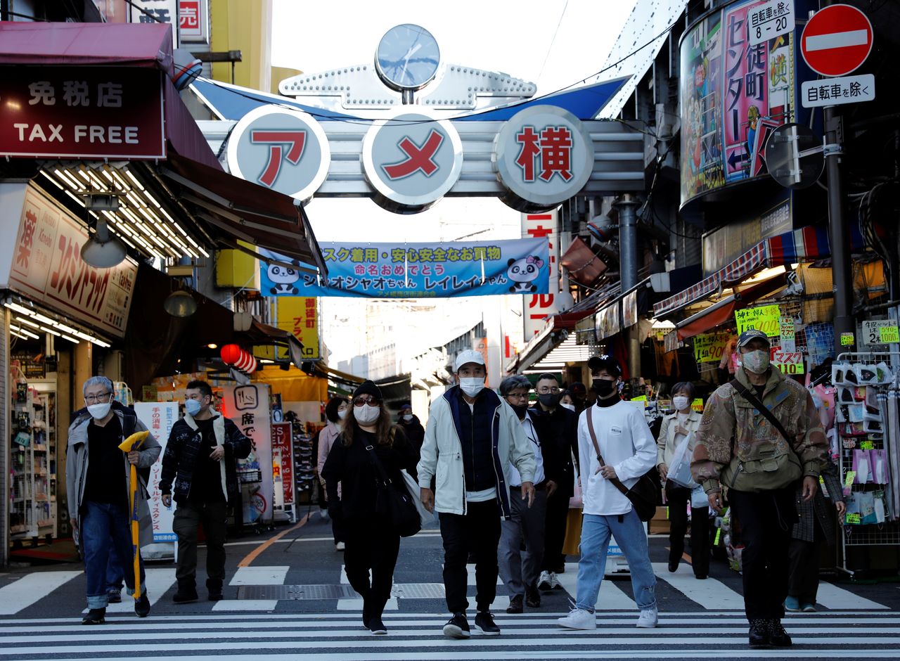 مشاة يرتدون أقنعة واقية وسط تفشي جائحة كورونا، يشقون طريقهم في منطقة التسوق الشهيرة أمي يوكو في طوكيو، اليابان، 1 ديسمبر/ كانون الأول 2021. كيم كيونغ هوون/ رويترز. 
