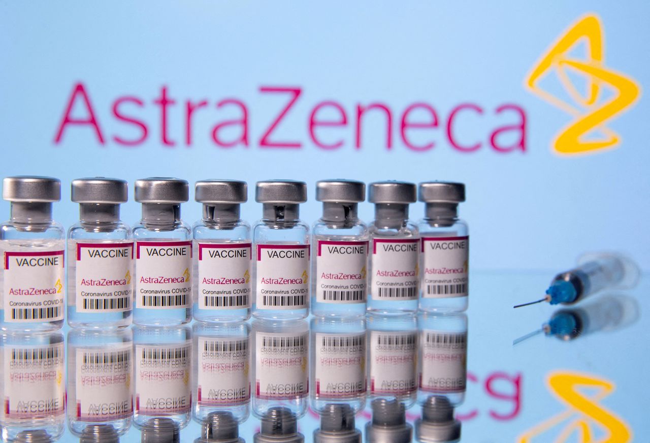 قنينات من لقاح أسترازينيكا الواقي من الإصابة بفيروس كورونا أمام شعار الشركة في صورة من أرشيف رويترز.