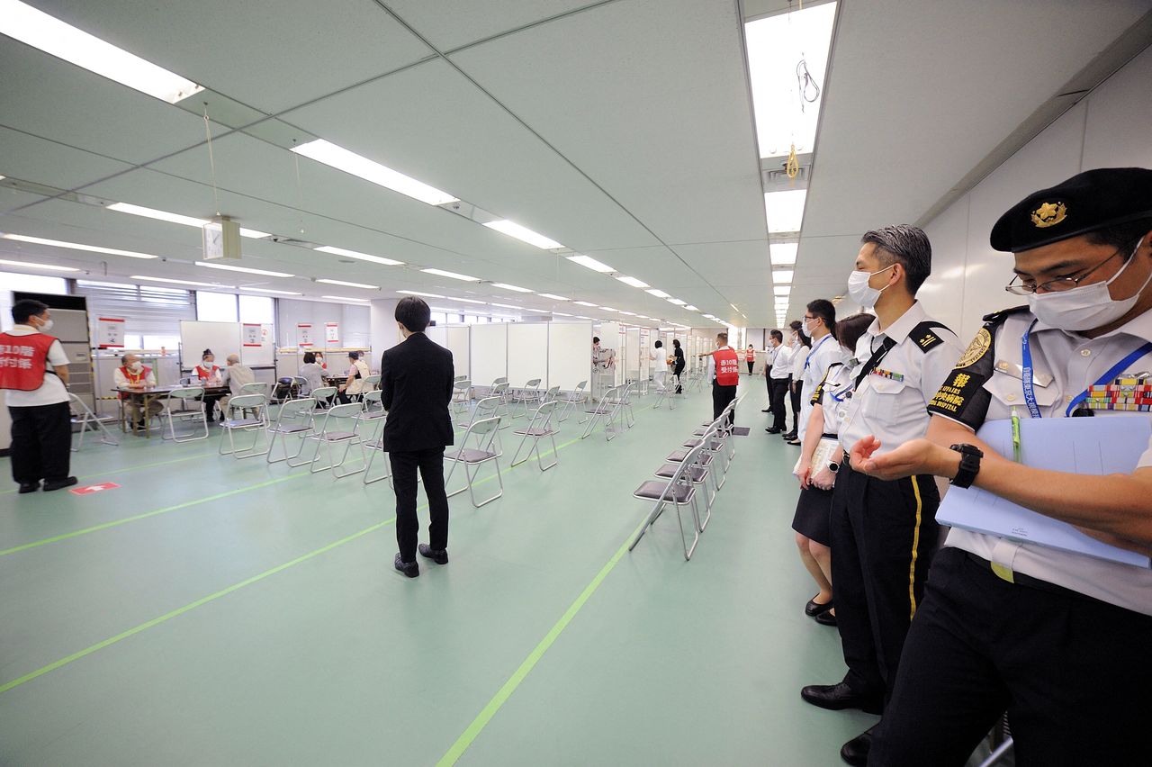 فرد من قوات الدفاع الذاتي اليابانية خلال وجوده في موقع تطعيم جماعي ضد فيروس كورونا في طوكيو يوم 9 يونيو حزيران 2021. صورة لرويترز من ممثل لوكالات الأنباء.