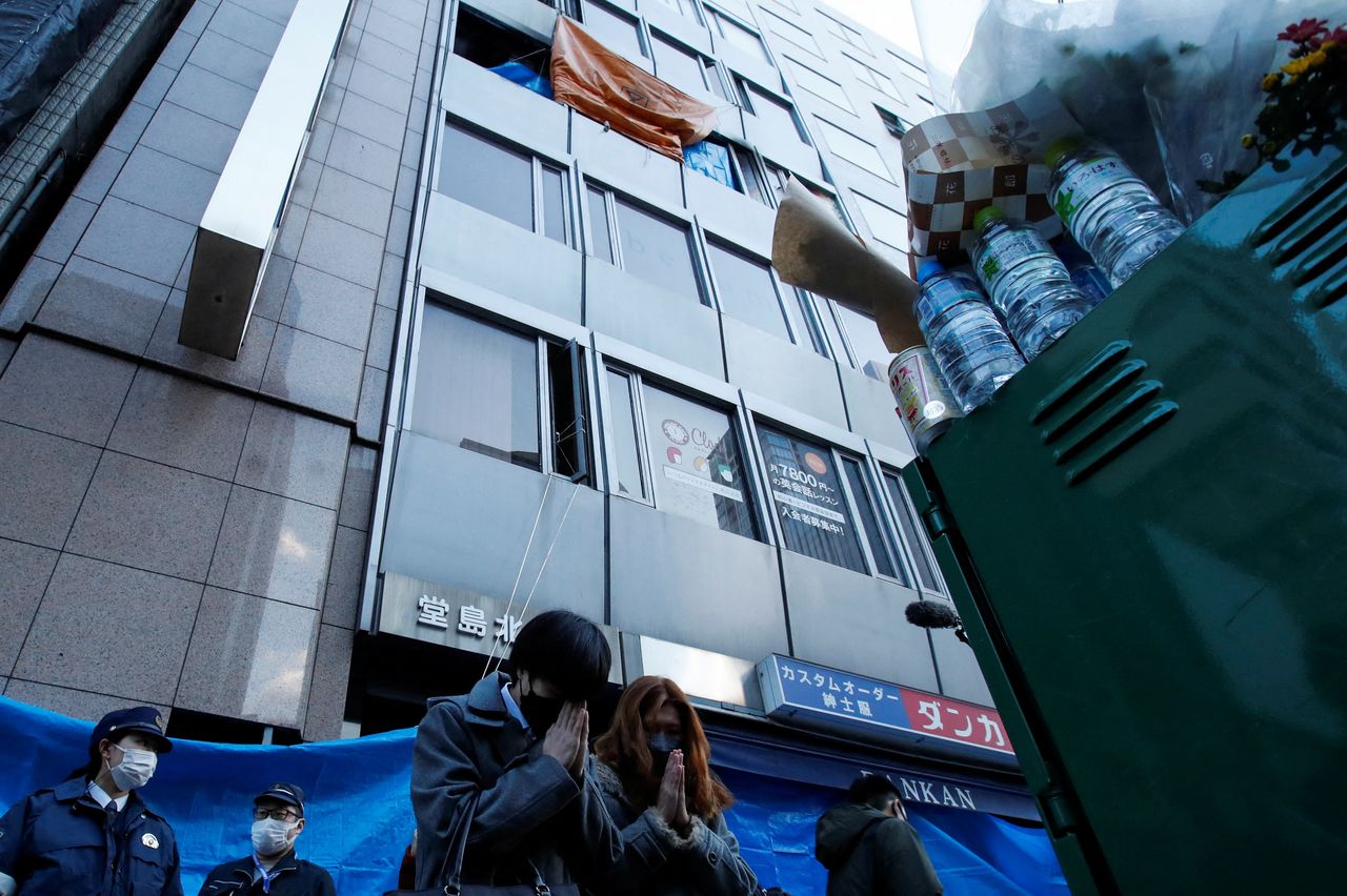 معزون يؤدون الصلوات على أرواح ضحايا حريق بعيادة للطب النفسي وذلك أمام المبنى الذي يضم العيادة في مدينة أوساكا اليابانية يوم السبت. تصوير:رويترز.