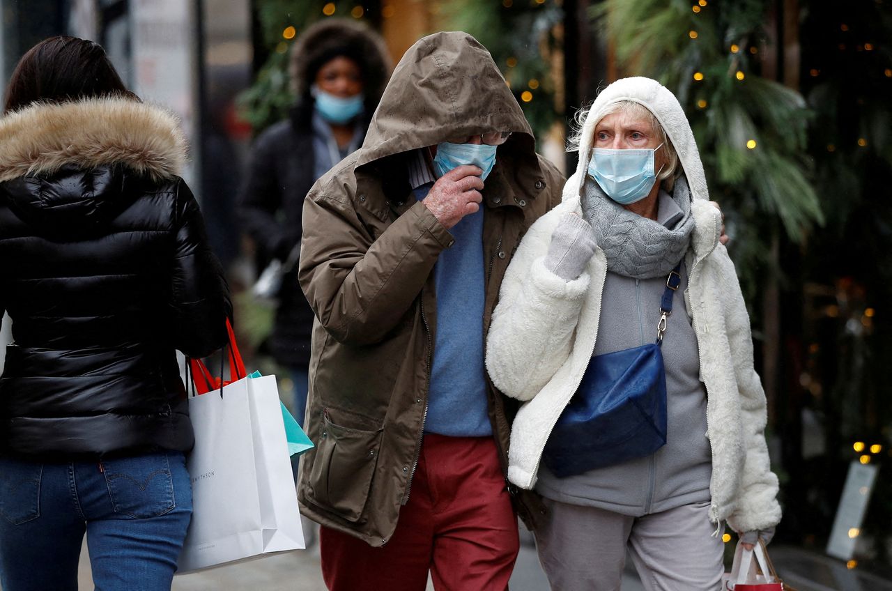 أفراد يضعون كمامات للوقاية من فيروس كورونا في لندن يوم 11 ديسمبر كانون الأول 2021. تصوير: بيتر نيكولز - رويترز.