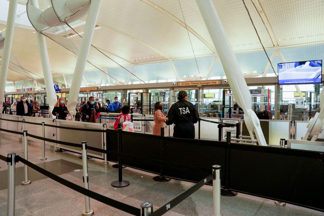 مسافرون عالقون في مطار جون كنيدي الدولي في كوينز بنيويورك بعد إلغاء رحلات جوية بسبب تفشي سلالة أوميكرون لفيروس كورونا يوم الجمعة. تصوير: ديو-ناليو شيري - رويترز.
