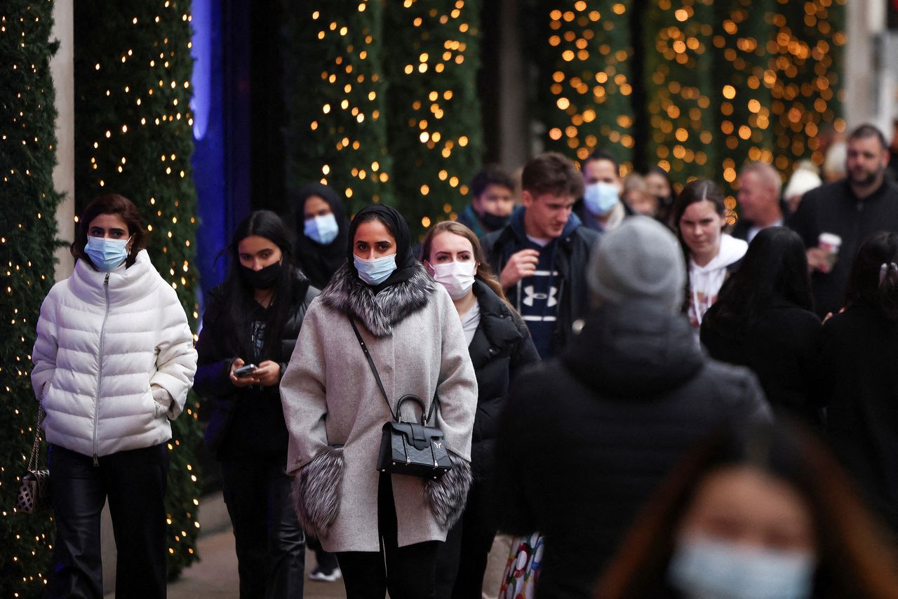 أشخاص يضعون كمامات للوقاية من فيروس كورونا في لندن يوم23 ديسمبر كانون الأول2021. تصوير: هنري نيكولاس - رويترز.