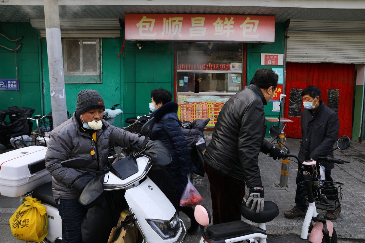 أشخاص يضعون كمامات في أحد الأسواق ببكين يوم 14 يناير كانون الثاني 2022. تصوير: تينجشو وانغ - رويترز