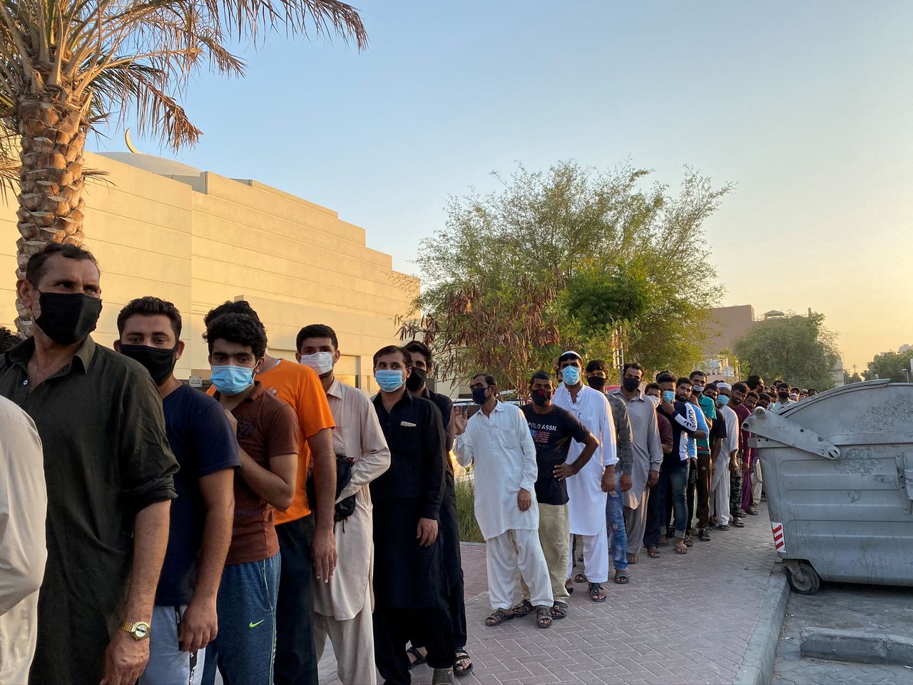 صورة من أرشيف رويترز لرجال يصطفون للحصول على تبرعات في دبي بعد أن فقدوا وظائفهم بسبب فيروس كورونا.