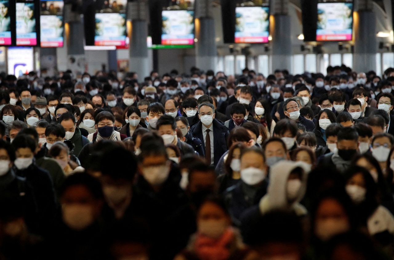 ركاب يرتدون أقنعة واقية للوجه وسط جائحة فيروس كورونا، يشقون طريقهم في محطة قطار في طوكيو، اليابان، 17 يناير/ كانون الثاني 2022. رويترز / كيم كيونغ هون. 