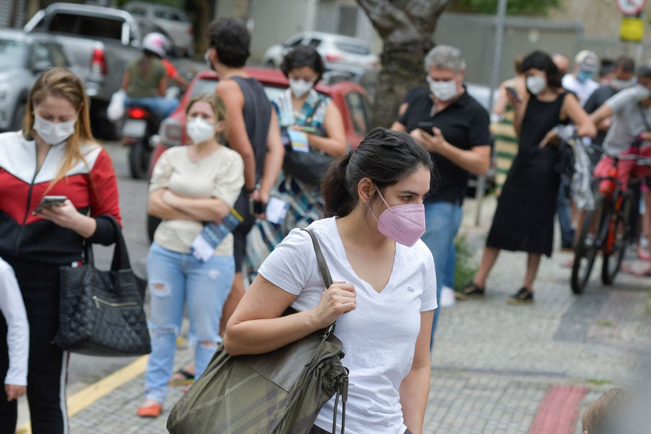 أشخاص يصطفون للخضوع لفحص سريع للكشف عن فيروس كورونا في موقع اختبار في بيلو هوريزونتي بالبرازيل يوم 16 يناير كانون الثاني 2022. تصوير:رويترز.
