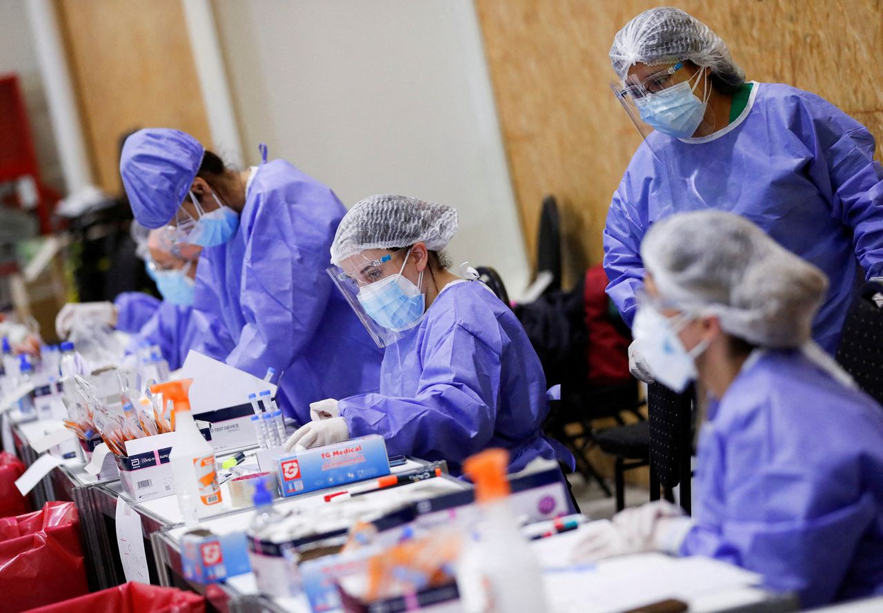 العاملون بالقطاع الصحي خلال تواجدهم في مركز اختبار فيروس كورونا في الأرجنتين في السادس من يناير كانون الثاني 2022. تصوير: أغوستين ماركاريان - رويترز.