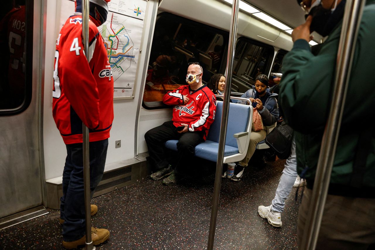 أشخاص يضعون كمامات في مترو واشنطن بواشنطن يوم 18 يناير كانون الثاني 2022. تصوير: شانون ستابلتون - رويترز