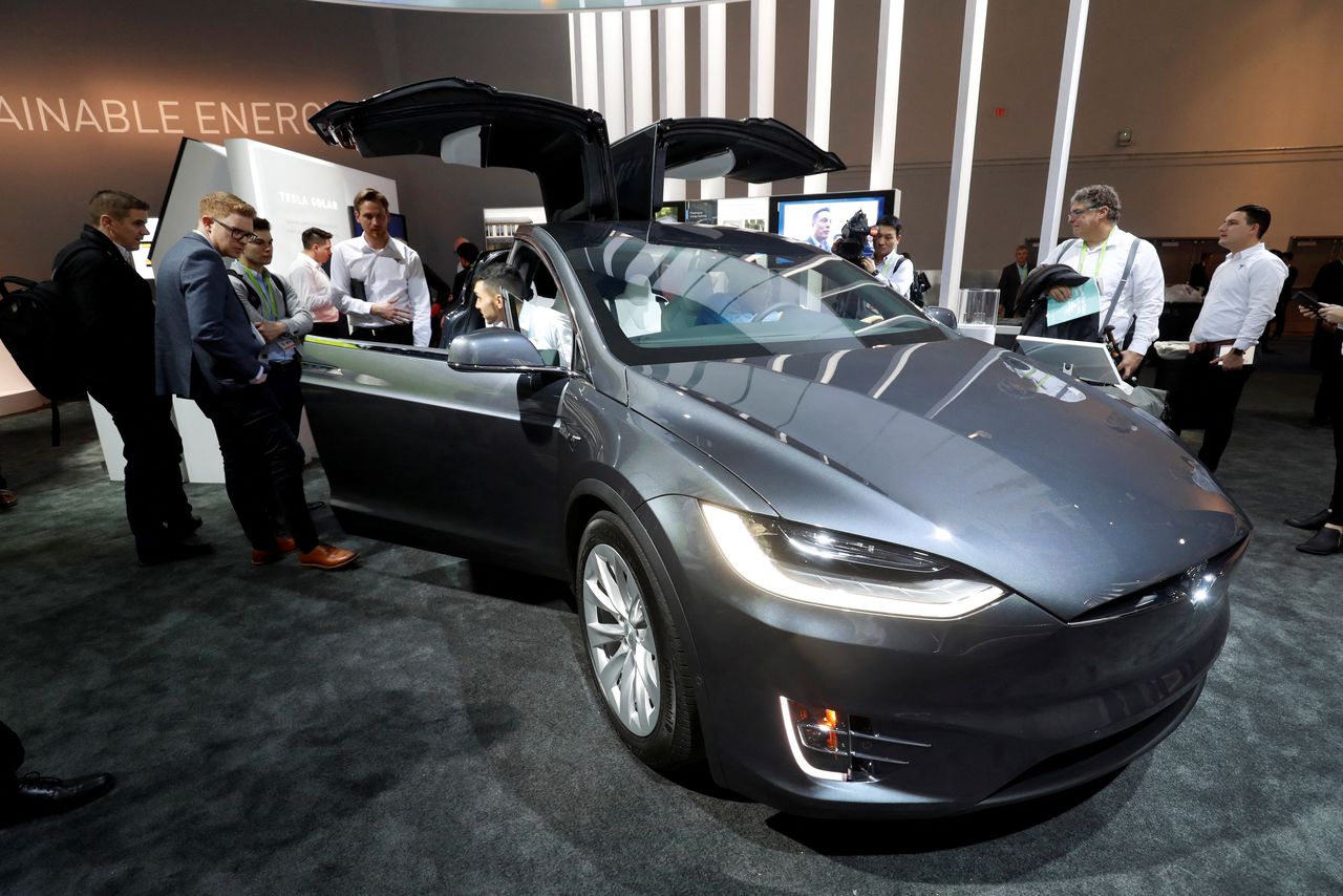 الحاضرون يلقون نظرة على طراز Tesla Model X الذي يعمل ببطاريات باناسونيك في مركز مؤتمرات لاس فيغاس خلال معرض CES 2018 في لاس فيغاس ، نيفادا، الولايات المتحدة ، 9 يناير/ كانون الثاني 2018. ستيف ماركوس/ رويترز.  