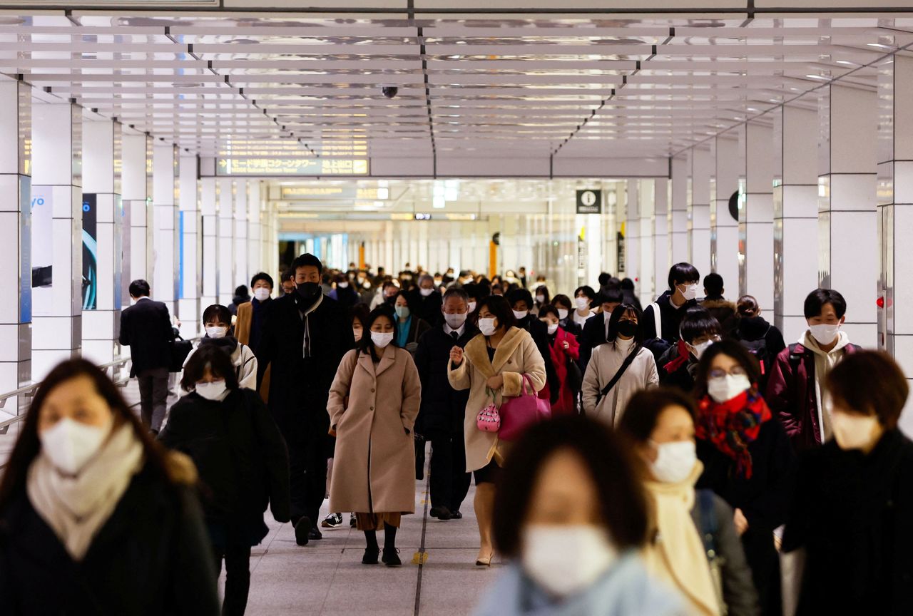 (مارة يرتدون أقنعة واقية يسيرون في باحة محطة قطار، وسط جائحة فيروس كورونا في طوكيو، اليابان، 9 فبراير/ شباط 2022. رويترز / إيسى كاتو)