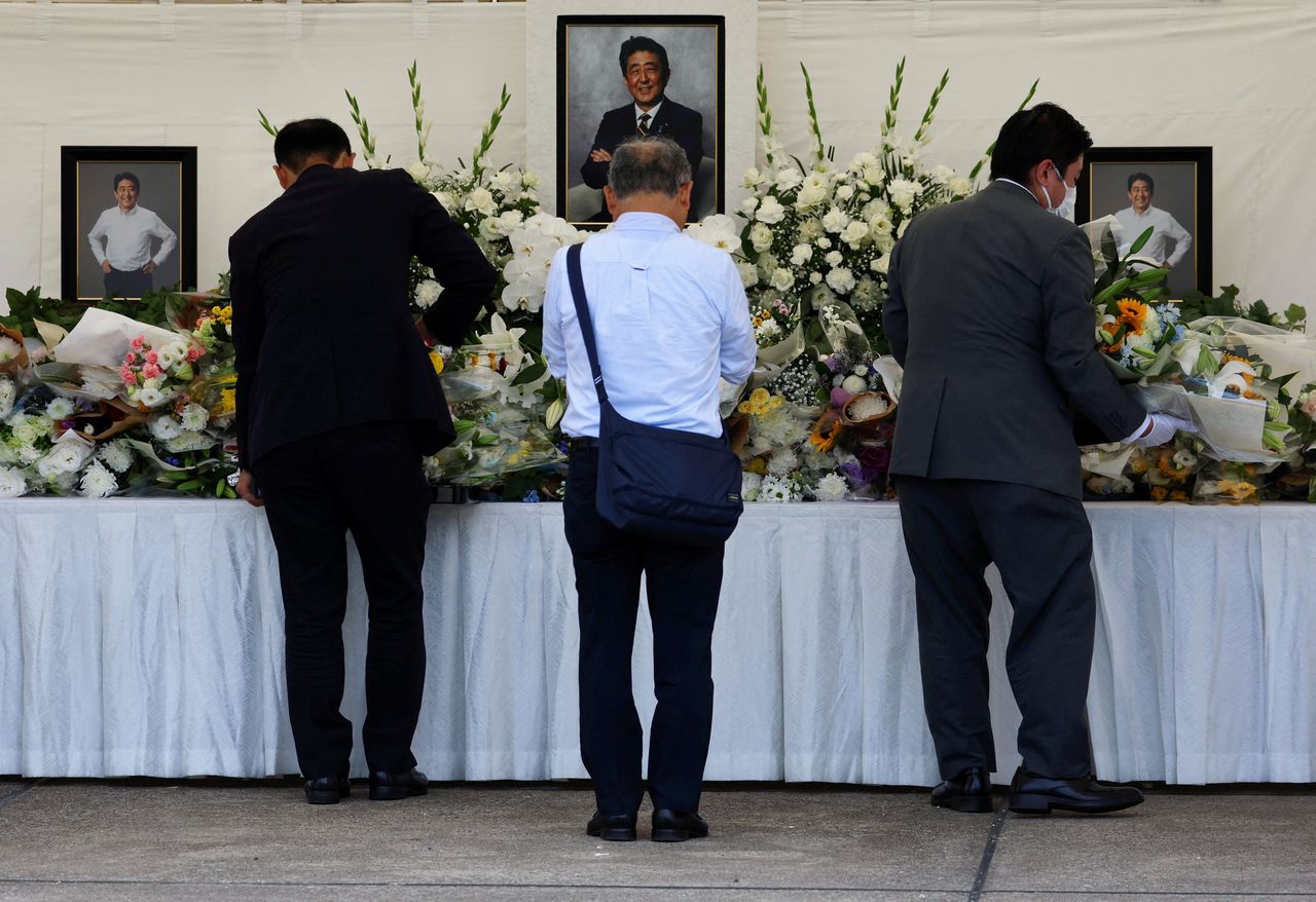 بعض من الناس يضعون أكاليل الزهور تعبيرًا عن تعازيهم لرحيل رئيس الوزراء السابق شينزو آبي في معبد زوجوجي بطوكيو في الثامن من يوليو/ تموز 2023. (رويتزو)