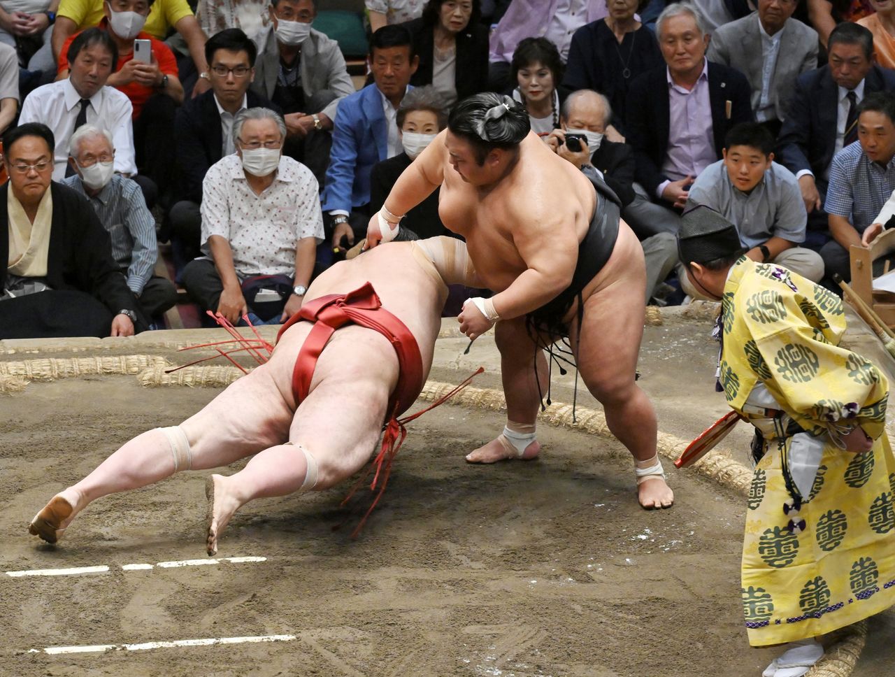  تاكاكيشو على اليمين يتغلب على أتاميفوجي بطرحه أرضًا على أرضية حلبة ريوغوكو كوكوغيكان بطوكيو. (© جيجي برس)