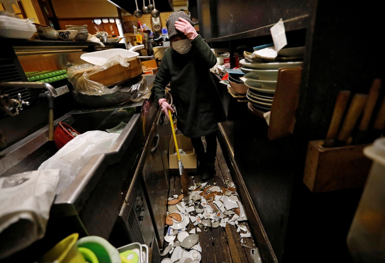 ميتسو هيسا، 70 عامًا، مالكة حانة إيزاكايا يابانية، تنظف الأطباق المكسورة في متجرها بعد زلزال قوي في إيواكي، محافظة فوكوشيما باليابان، 14 فبراير/ شباط 2021. رويترز / إيسي كاتو.