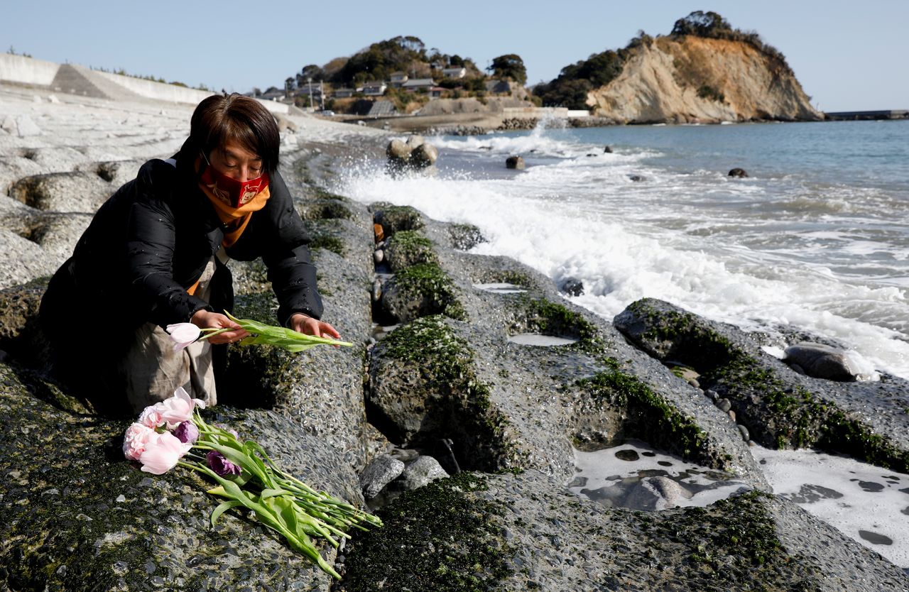 ماريكو أوداوارا تضع الزهور حدادًا على ضحايا الزلزال والتسونامي الذي أسفر عن مقتل الآلاف وتسبب في أسوأ حادث نووي منذ تشيرنوبيل، خلال الذكرى العاشرة في إيواكي، محافظة فوكوشيما، اليابان، 11 مارس/ آذار 2021. كيم كيونغ هون/ رويترز.
