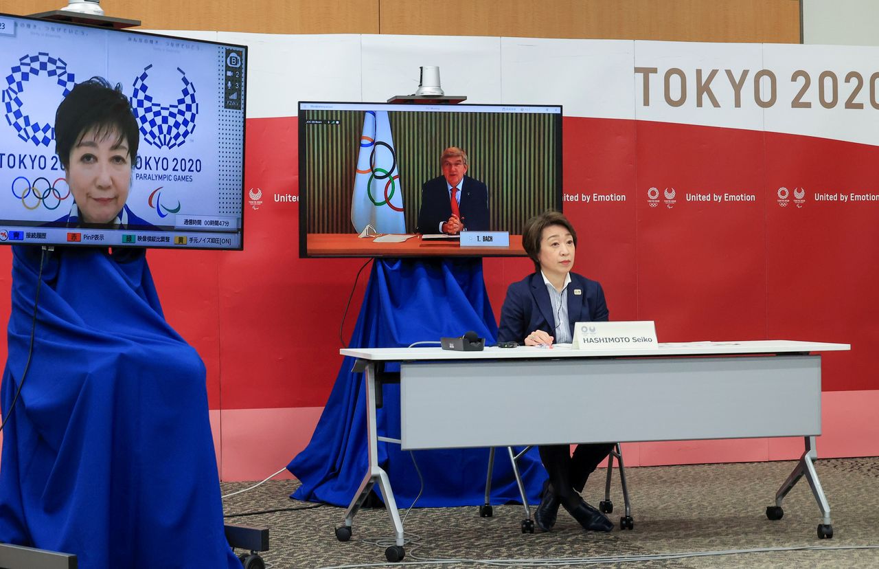 رئيس اللجنة الأولمبية الدولية (IOC) توماس باخ (على الشاشة) يلقي كلمة افتتاحية بينما تستمع رئيسة اللجنة المنظمة لأولمبياد طوكيو 2020 سيكو هاشيموتو، في اجتماع خماسي للألعاب الأولمبية والبارالمبية في طوكيو 2020 مع رئيس اللجنة البارالمبية الدولية (IPC) أندرو بارسونز ومحافظة طوكيو يوريكو كويكي ووزيرة الأولمبياد اليابانية تامايو ماروكاوا في طوكيو، اليابان، 20 مارس/ آذار 2021. يوشيكازو تسونو / رويترز.