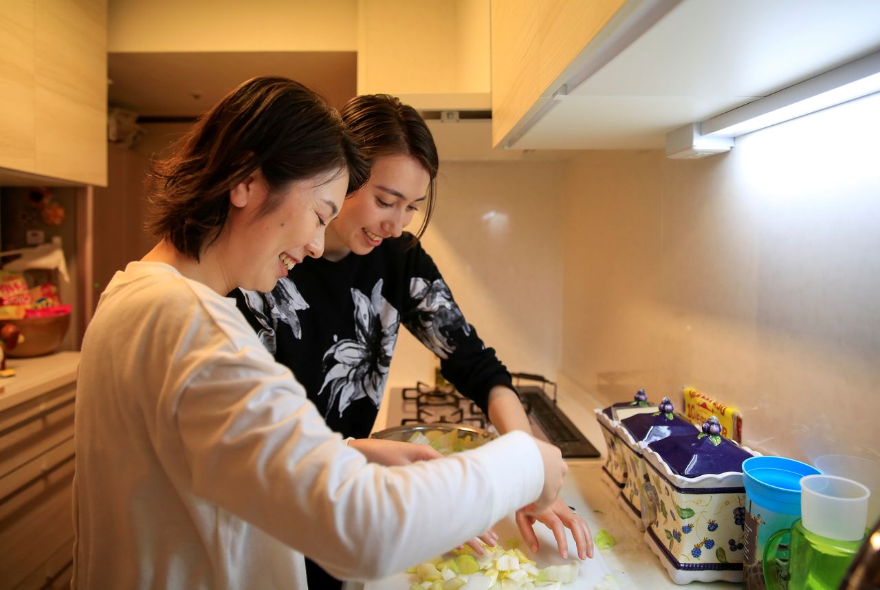 الزوجتان جيني ونارومي تطبخان معًا في منزل والدي جيني في طوكيو، اليابان، 19 مارس/ آذار 2021. التقطت الصورة في 19 مارس/ آذار 2021. رويترز / أكيرا توموشيجي.