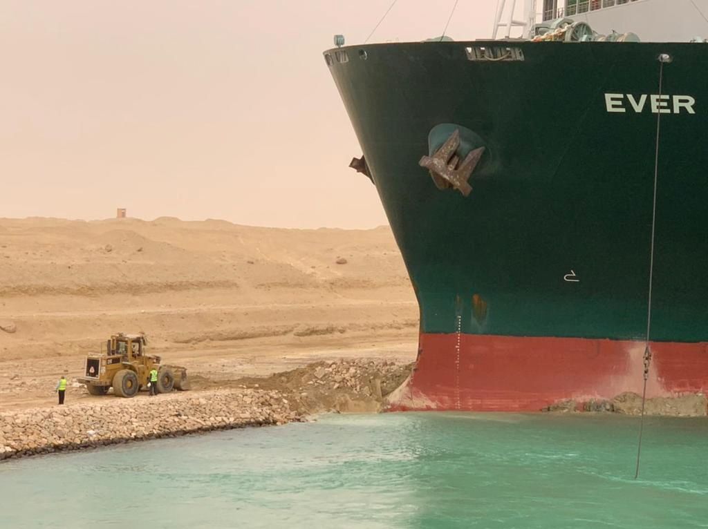 عمال بجوار سفينة الحاويات ”إيفرغيفن“ التي تعرضت لرياح قوية وجنحت في قناة السويس، مصر، 24 مارس/ آذار 2021. هيئة قناة السويس / منشور عبر رويترز.