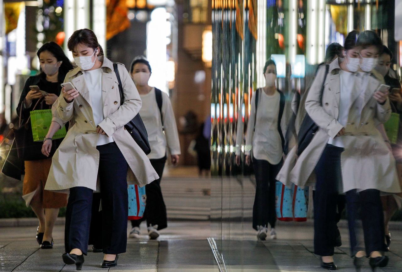 مارة يرتدون أقنعة واقية يسيرون في الشارع وسط تفشي فيروس كورونا في طوكيو، اليابان، 22 أبريل/ نيسان 2021. رويترز / أندرونيكي كريستودولو.