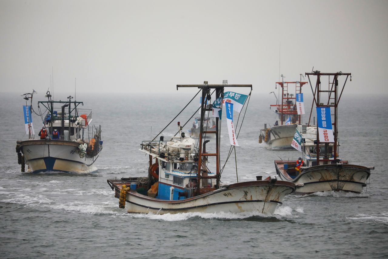 صيادون بمراكب صيد بكوريا الجنوبية يحتجون على قرار اليابان تصريف المياه الملوثة من محطة فوكوشيما النووية المعطوبة في البحر في صورة التقطت يوم الجمعة. تصوير: كيم هونج-جي - رويترز.