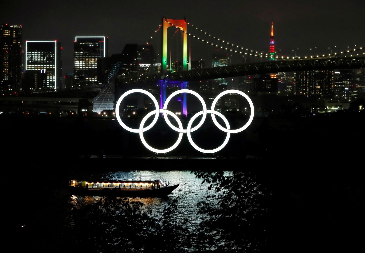 شعار الالعاب الأولمبية يزين جسرا وبرجا في العاصمة اليابانية طوكيو يوم 14 أبريل نيسان 2021. تصوير: إيسي كاتو - رويترز.