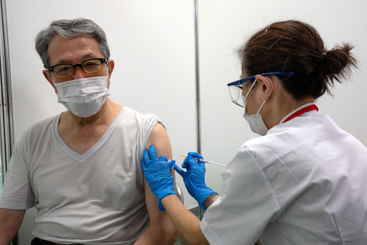 شخص متقاعد يتلقى لقاح كورونا في مركز التطعيم الشامل الذي افتتح حديثًا في طوكيو، اليابان، 24 مايو/ أيار 2021. رويترز/ كارل كورت.