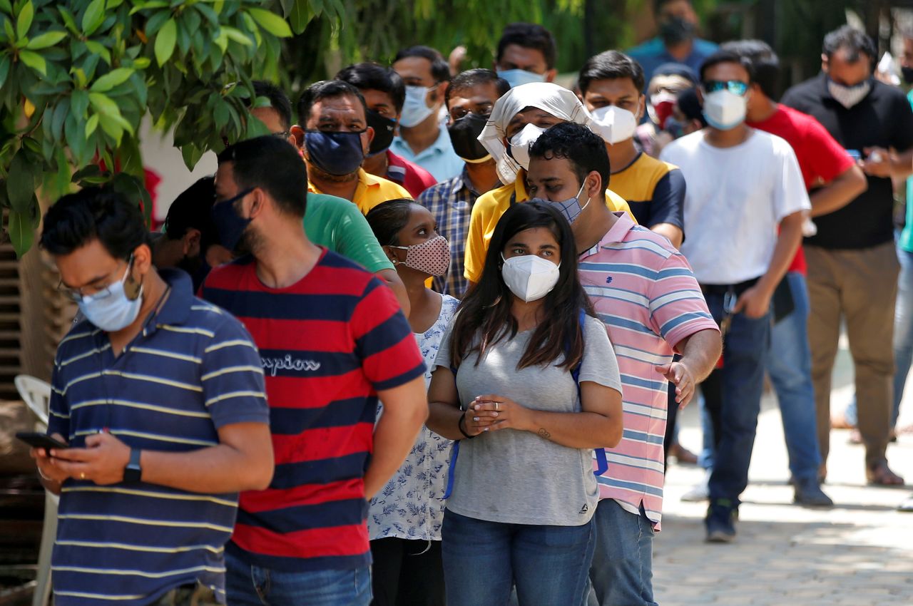 أشخاص يضعون كمامات ينتظرون الحصول على جرعة من لقاح واق من الإصابة بفيروس كورونا في أحمد أباد في الأول من مايو أيار 2021. تصوير: أميت ديف - رويترز