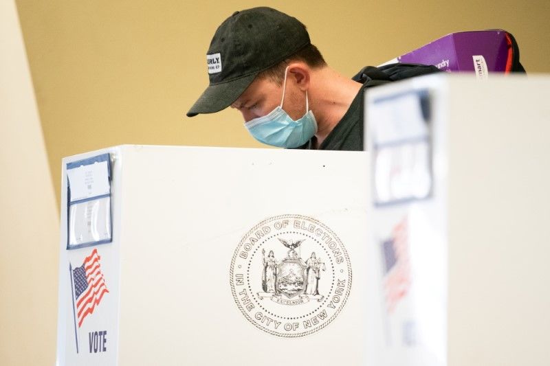 رجل يضع كمامة خلال التصويت المبكر لانتخابات البلدية في نيويورك يوم الأحد. تصوير: جيناه موون - رويترز