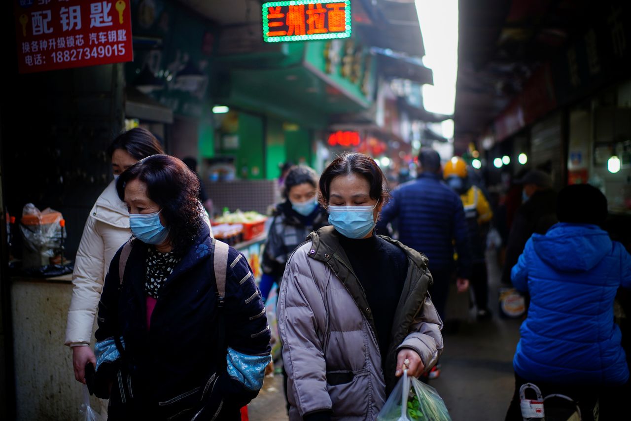 أشخاص يضعون كمامات للوقاية من فيروس كورونا في مدينة ووهان الصينية يوم الثامن من فبراير شباط 2021. تصوير: آلي سونغ - رويترز.