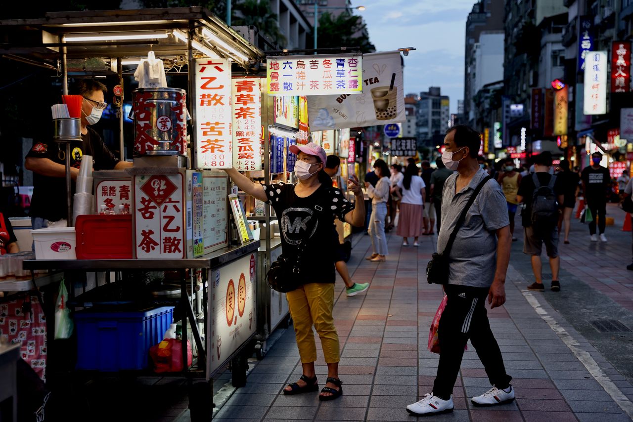 أشخاص يضعون كمامات على وجوههم في تايوان يوم الجمعة - رويترز